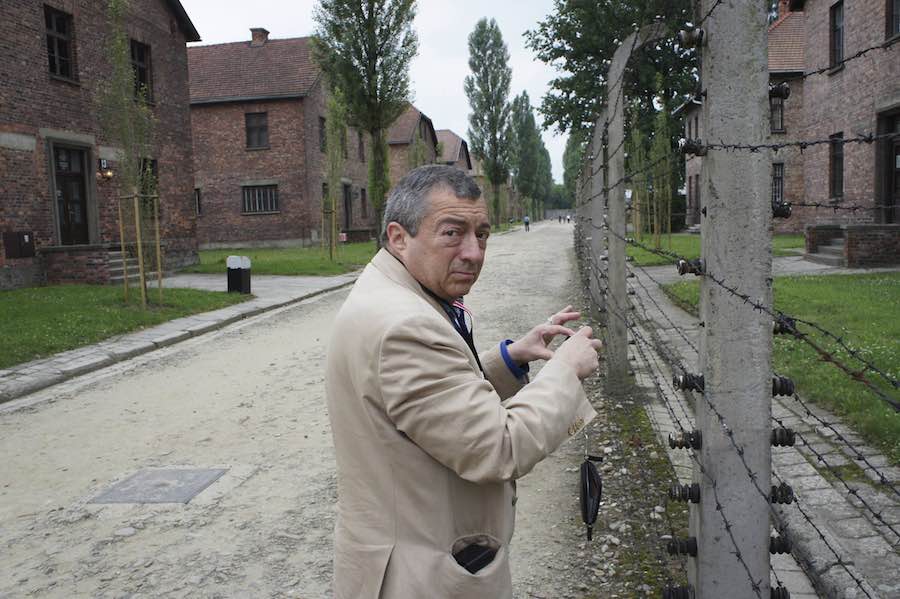 Philippe Mora stands next to one of the camp’s infamous barbed wire fences. 