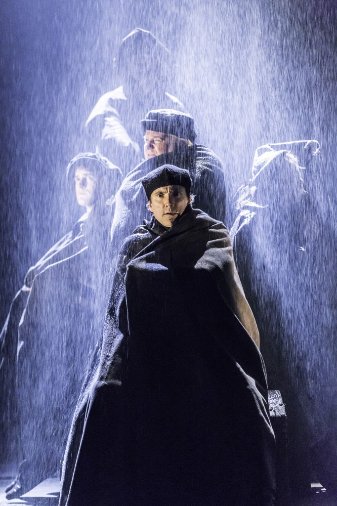 Men standing in rain in a scene from Wolf Hall
