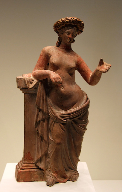 a statue of a female figure leaning on a pillar