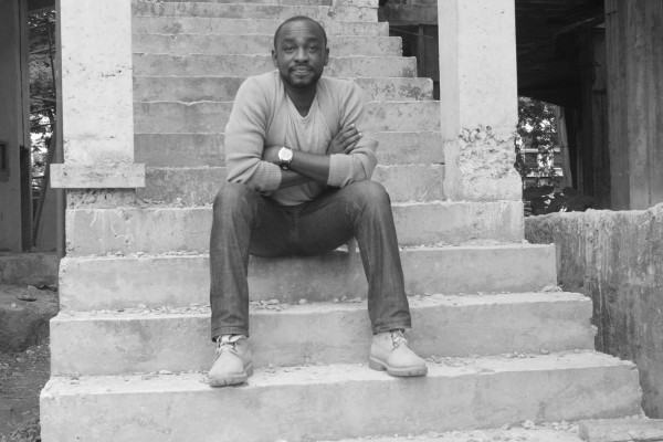 black and white photo of a young black male sitting on steps