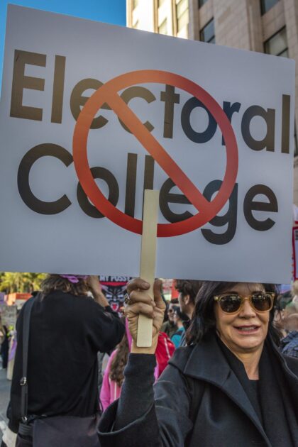 Demonstrator at the 2017 Women's March holds a sign protesting for electoral college reform