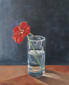 One of two collaborations. A painting of a red flower in a clear glass half filled with water. It is on a brown desk top in front of a blue wall.